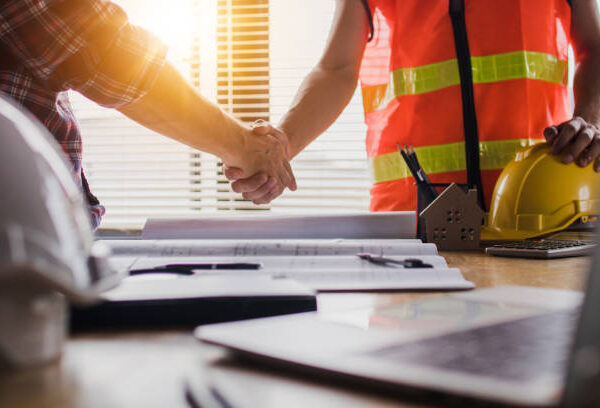 Handshake of two business man, after architect working and planning blueprint, Engineering objects on workplace
