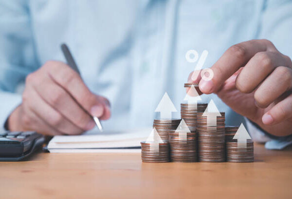 Businessman putting coin stacking with up arrow and percentage sign for increase financial interest rate and business investment growth from dividend concept.