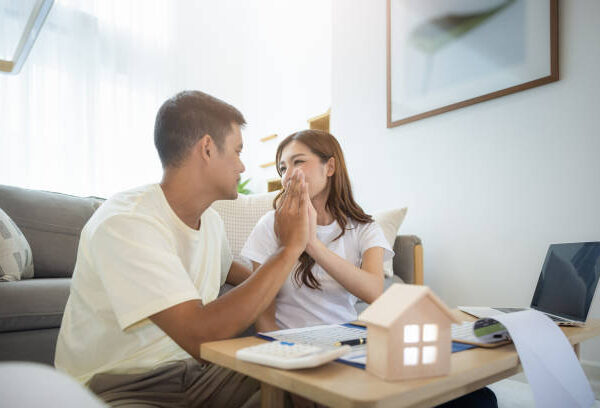 Asian couple in home or house. To compare prices, interest, credit and calculate together. Include laptop, calculator and document on table. Concept for marriage, loan, finance, insurance, mortgage, real estate and property.