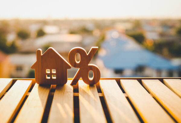 Percentage and house sign symbol icon wooden on wood table. Concepts of home interest, real estate, investing in inflation.