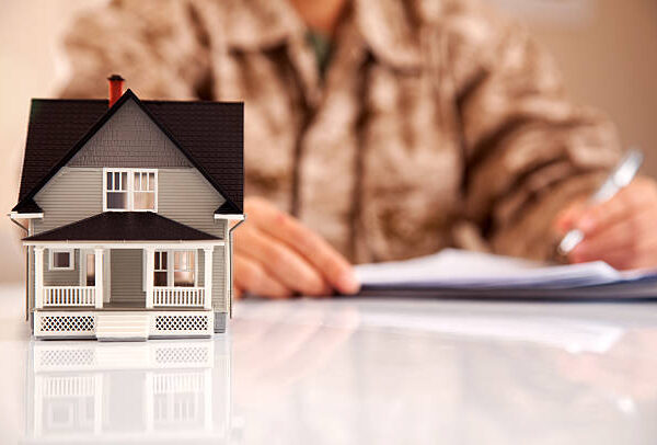 Service member wearing Marines uniform (MARPAT) filling real estate related paperwork.