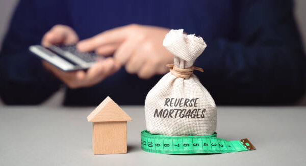 Reverse mortgage concept. Type of loan available to homeowners aged 62 or older, allowing them to convert part of the equity in their home into cash. Business and finance. money bag and businessman