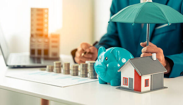 Businessman holding green umbrella on house home insurance, housing, real estate, mortgage, protection, safety, investment, business